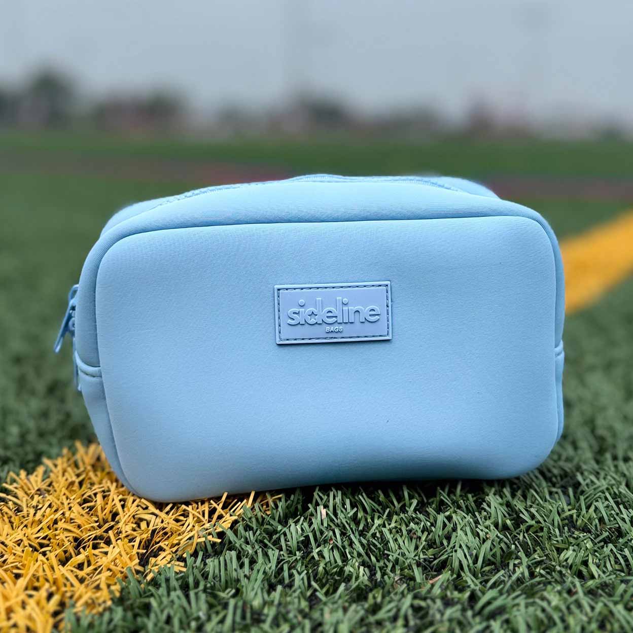 Blue pouch with 'sideline' branding on grass