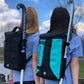 Two girls with the Gryphon Mini Freddie Backpack on their backs showing how the stick is in the bag.