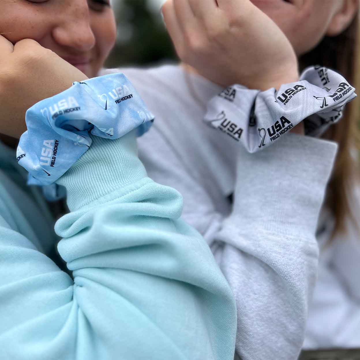 Two girls wearing the USA Field Hockey Scrunchies on their wrists