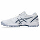 A white Asics field shoe with navy blue logo and heel accents, featuring a textured mesh upper and molded turf lugs, shown in a side profile on a white background.