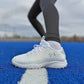 White athletic shoe on a blue turf with blurred background