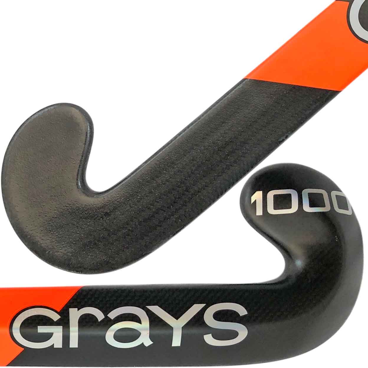 Detailed close-up of the toe and shaft of the Grays AC1000 DBS stick, showing the textured carbon fiber surface and bold “Grays 1000” branding with orange diagonal design.