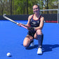 Field Hockey player Phia Gladieux kneeling and holding a TK Black Elephant Field Hockey Stick