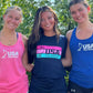 A girl wearing a USA Field Hockey Performance Long sleeve Tee between two wearing tank tops. 