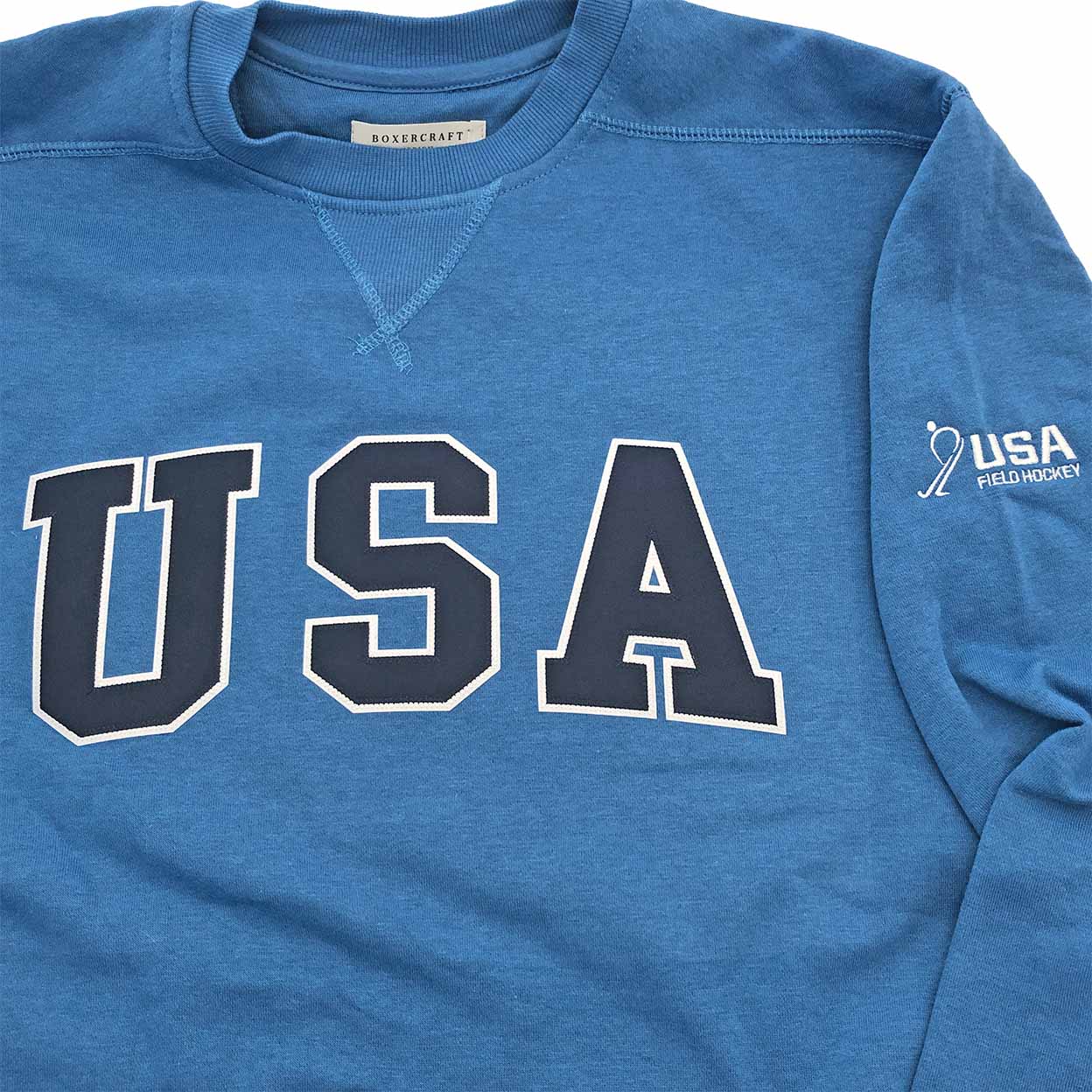 Blue sweatshirt with 'USA' printed on it, featuring a logo on the sleeve.