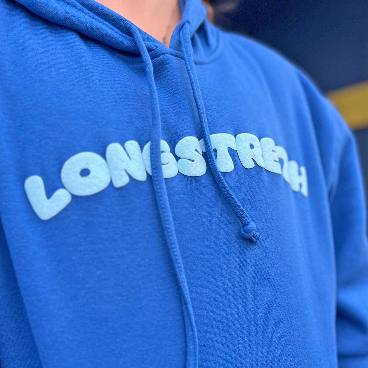 Blue hoodie with Longstreth text on a blurred background