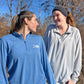 Two women wearing blue and gray USA shirts standing outdoors with trees in the background.