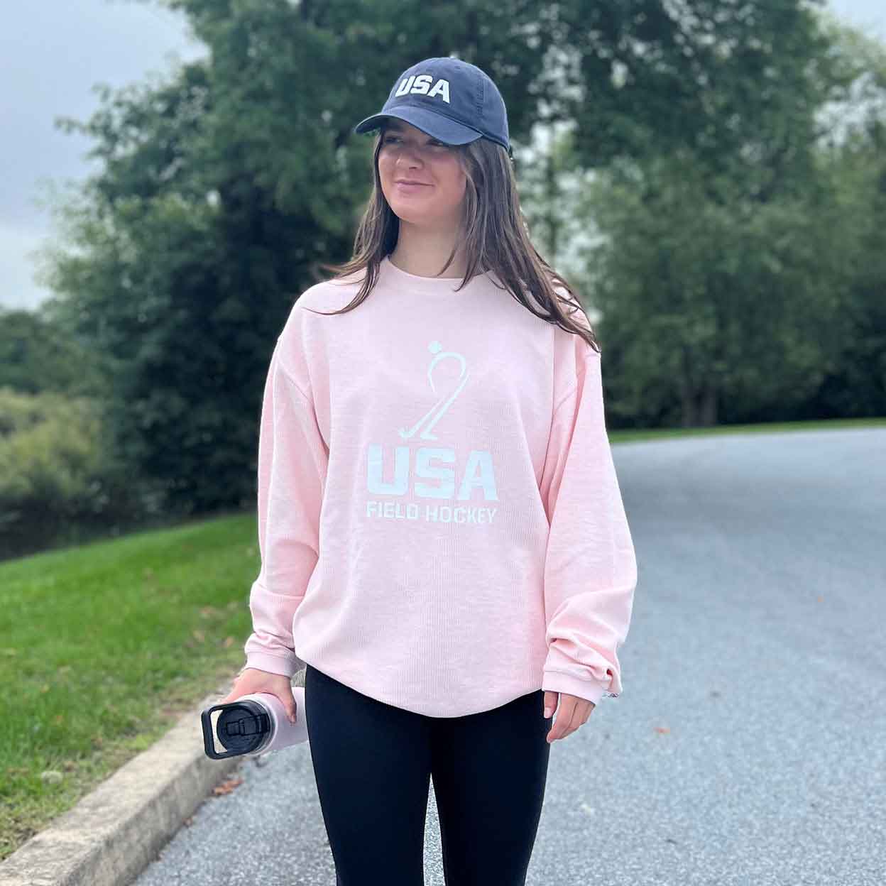 Model wearing a USA hat and a pink USA Field Hockey Ribbed Knit Sweatshirt