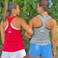 Two women wearing USA branded athletic wear standing outdoors with greenery in the background.