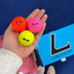 Hand holding three small balls with the Longstreth logo in the background.