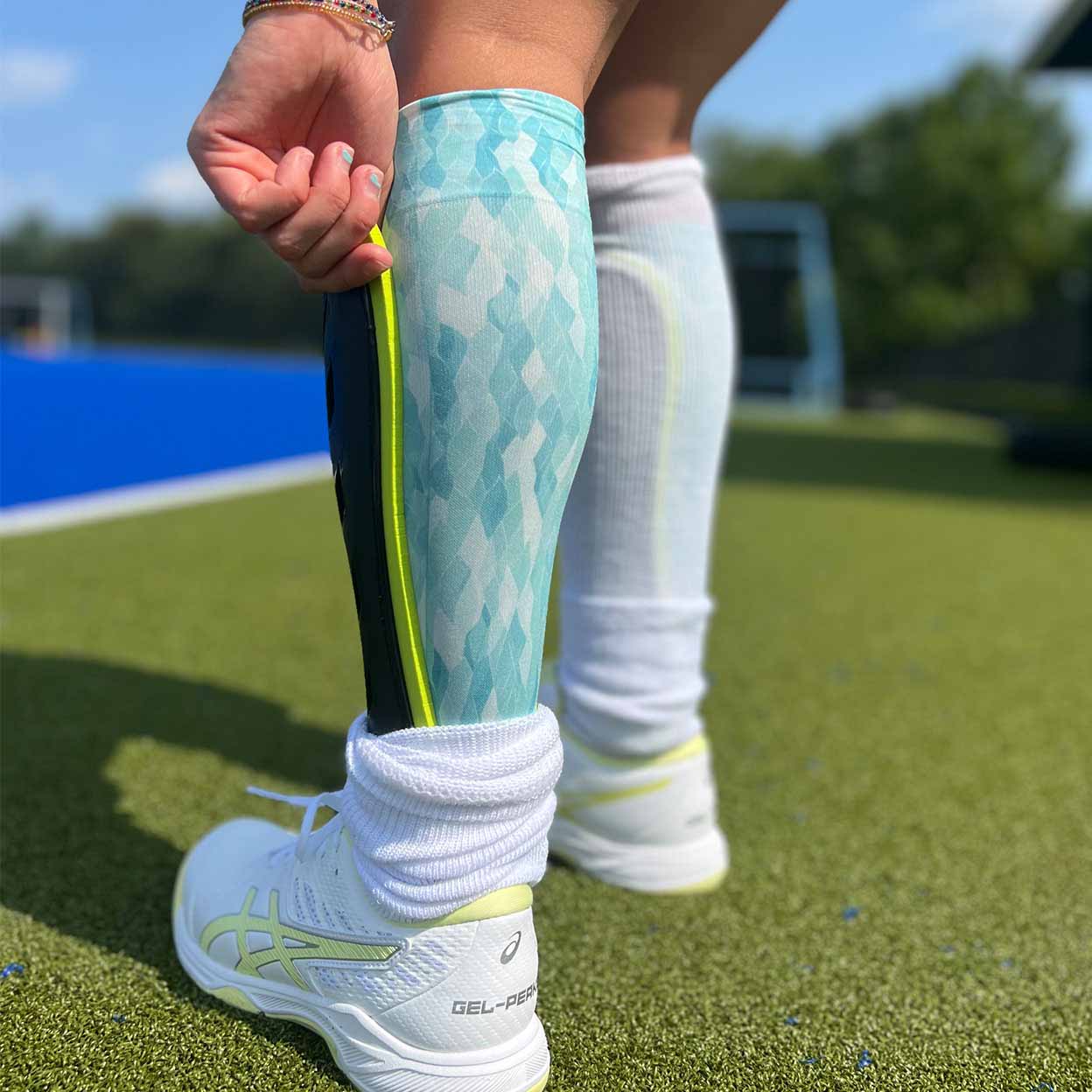 someone putting on the Grays G600 Field Hockey Shinguards.
