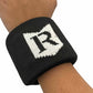 Black wristband with a white logo on a person's wrist against a white background