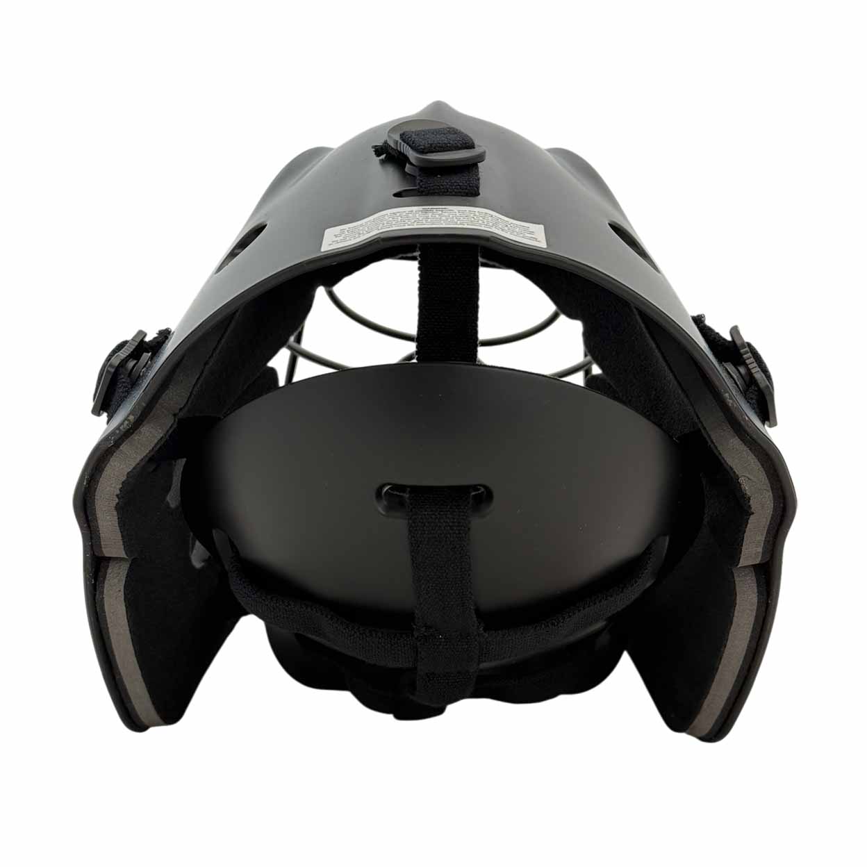 Black protective sports helmet with metal face guard, viewed from the back. The interior padding and strap are visible, along with adjustable side straps and top ventilation holes.
