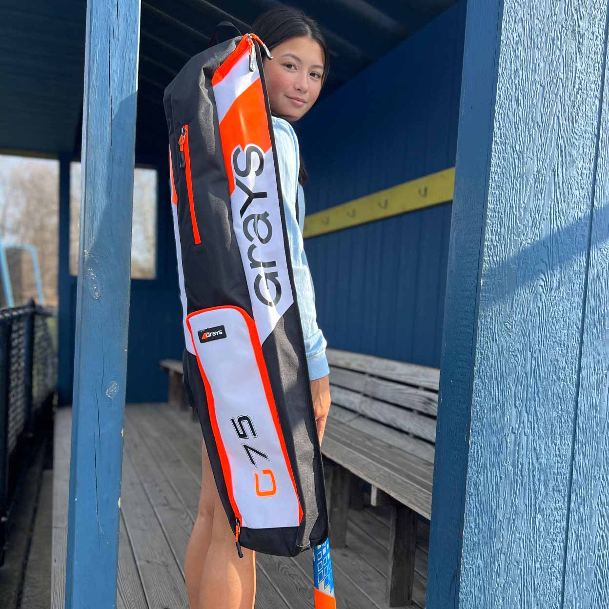 field hockey player with a black, white, and orange Grays G75 Stickbag.