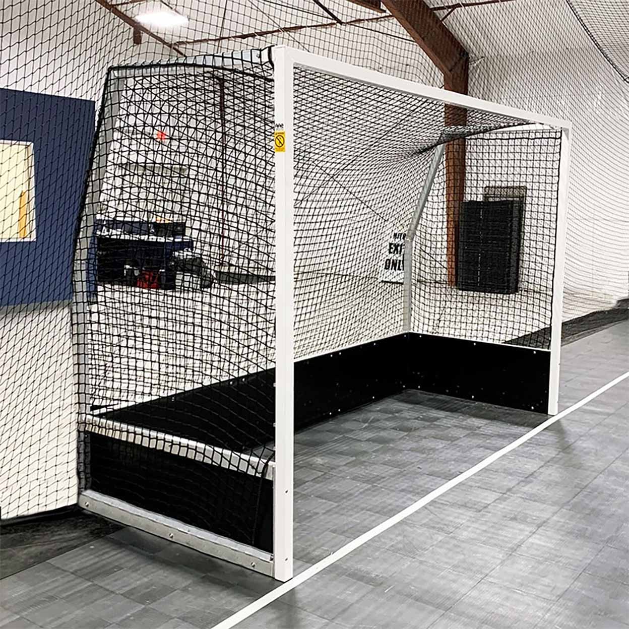 Indoor sports facility with a netted enclosure and goal.