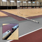 Indoor sports facility with basketball court and track, featuring a close-up of a metal track fixture.