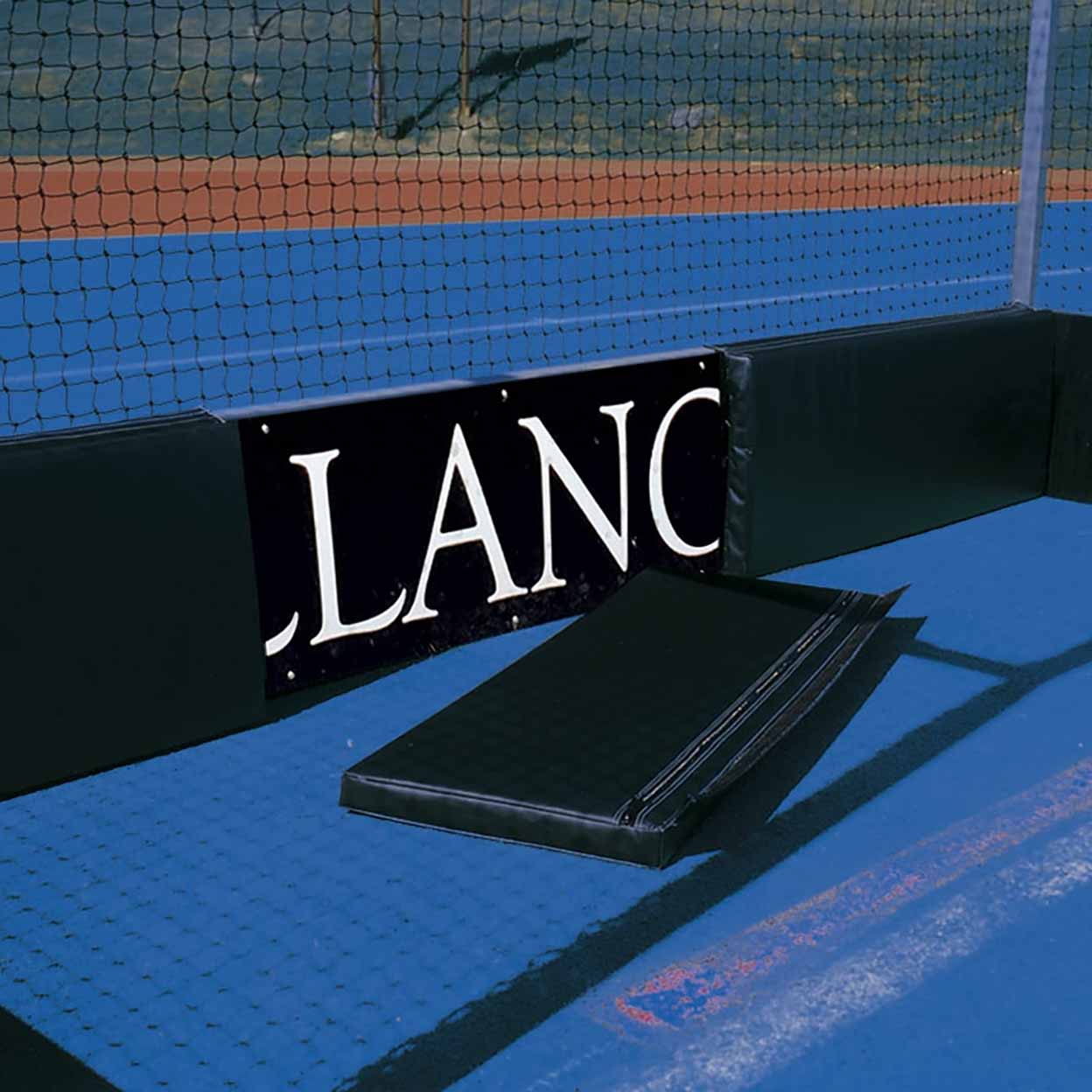 Black LANC sign on a field hockey court with blue surface and net in the background