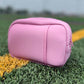 Pink pouch on artificial grass with a blurred background
