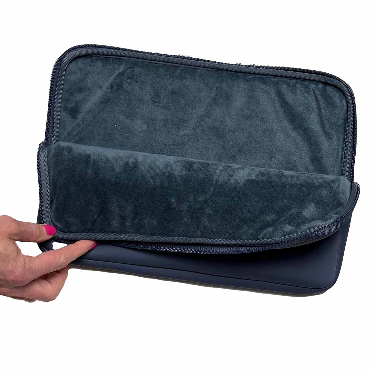 Interior of the navy laptop sleeve with a hand holding it on a white background