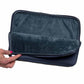 Interior of the navy laptop sleeve with a hand holding it on a white background
