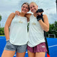 Two girls with their arms around each other wearing the USA Field Hockey Trapeze Tank.