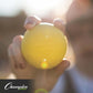 a person holding a yellow lacrosse ball up to the camera.