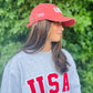 A girl wearing a red USA Field Hockey Relaxed Twill Hat.