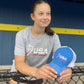 Model holding the USA Field Hockey Hat and wearing a USA hockey Tee