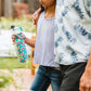 Young girl holding a O2 Cool Mist N Sip Water Bottle while her dad has his arm around her shoulder.