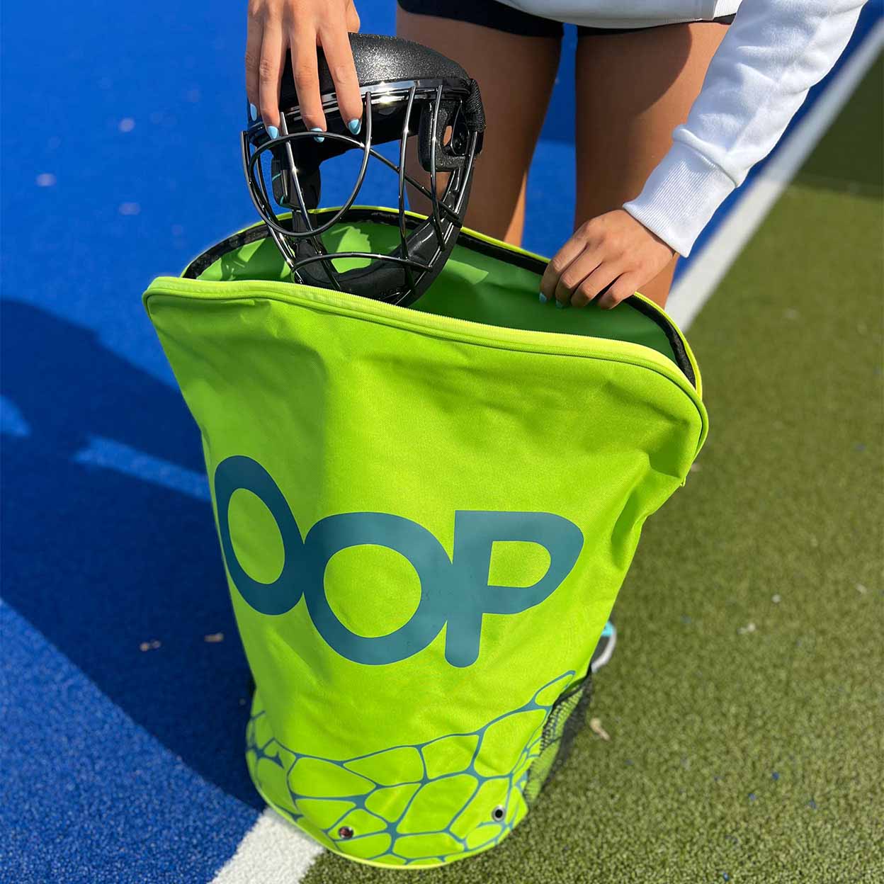Player putting a mask inside the OOP CarryMe Penalty Corner Bag