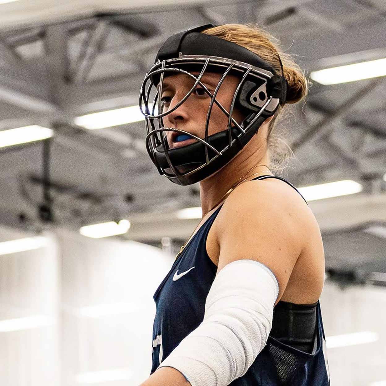 Person wearing a face mask and protective gear in an indoor sports facility