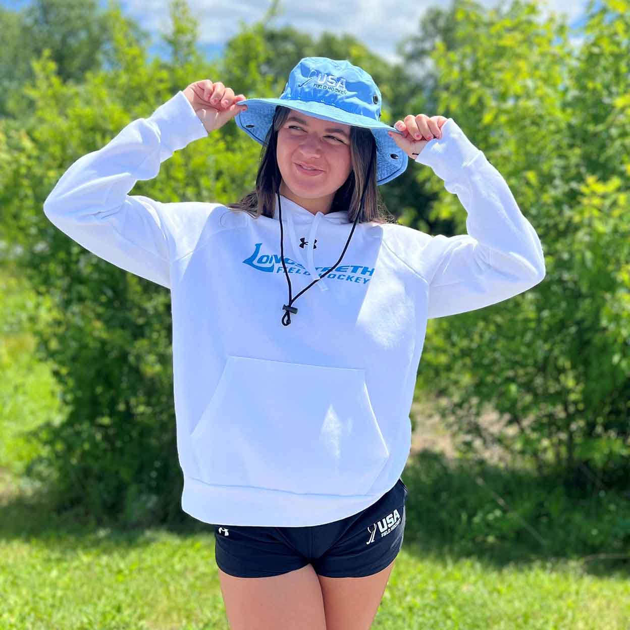 model in a hat wearing the Longstreth Under Armour Hooded Sweatshirt