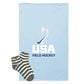 A light blue blanket featuring the USA Field Hockey logo, shown with a pair of gray and white striped socks on a plain white background.