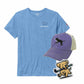 Blue t-shirt with field hockey design, purple cap with dog and stick graphic, and dog sticker on a white background