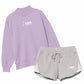 A two-piece women's loungewear set featuring a light purple mock-neck sweatshirt and heather gray drawstring shorts with white side panels and white USA graphics.