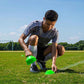 a man placing the Mini Neon Disc Cones on a field