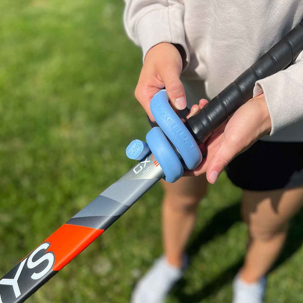 player putting LaceUp 12 oz. Field Hockey Training Weight on a stick