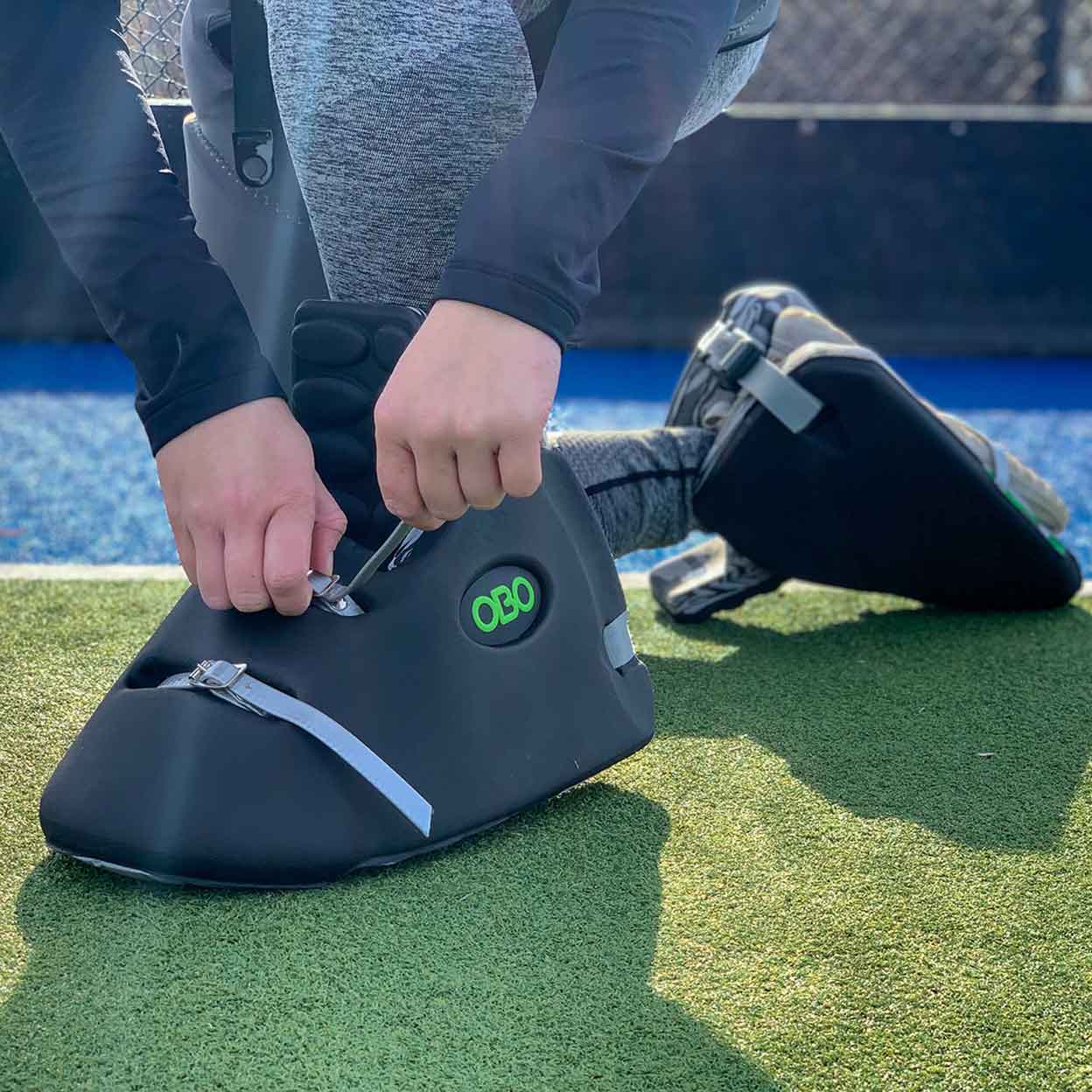 Person fixing the strap on a pair of OBO Robo Hi-Control Goalkeeping Kickers